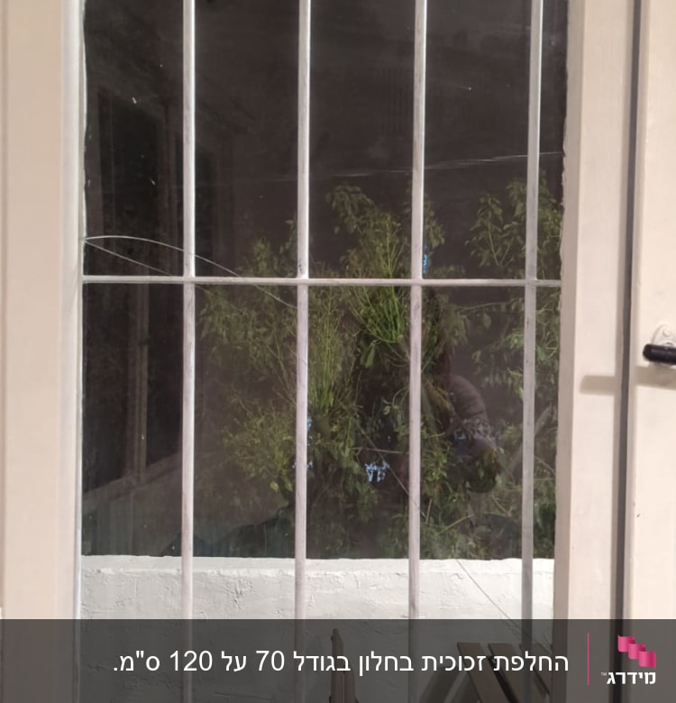 חלון זכוכית עם סורגים ולוחות עץ ברקע